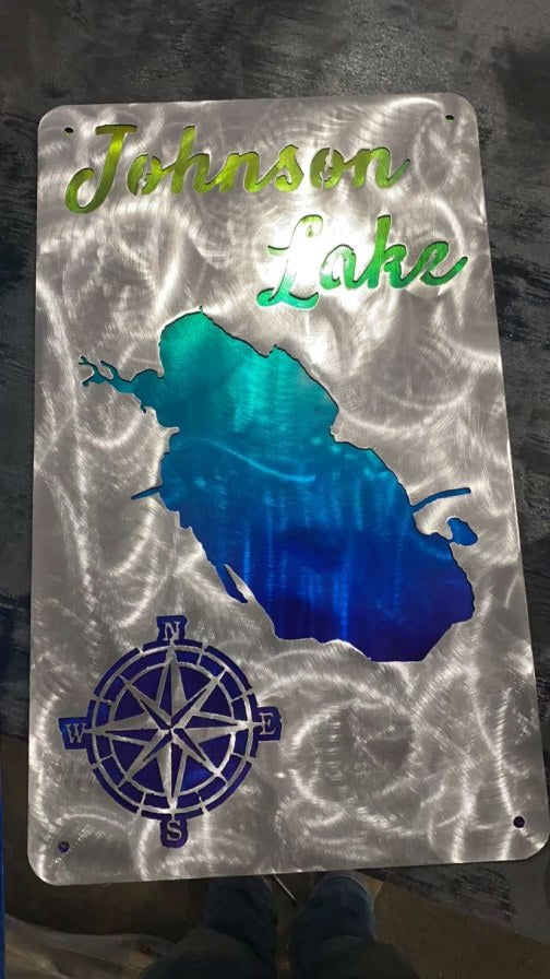 A finished custom aluminum lake sign on the shop floor, just off the cutting table